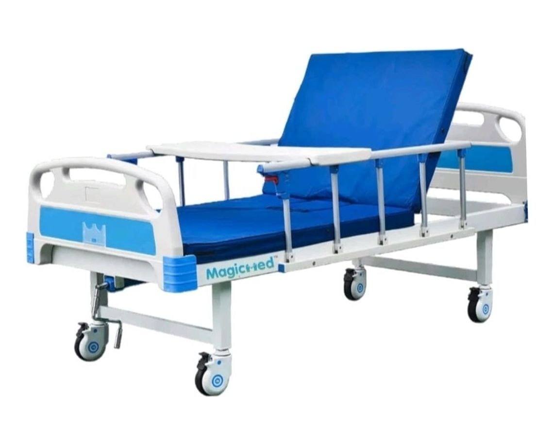 Manual hospital cot with blue mattress, side rails and an over-bed table