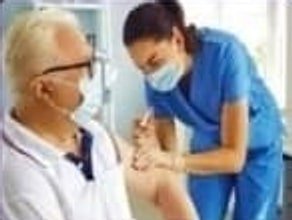 Nurse in a face mask attending to an elderly man